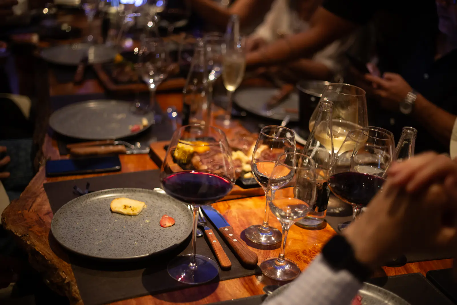 Mesa compartida con copas de tinto y blanco durante un evento privado